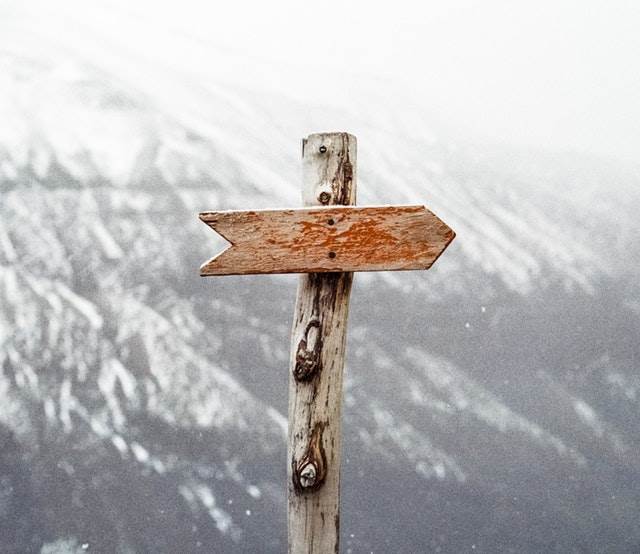 Wooden arrow nailed to post, pointing right