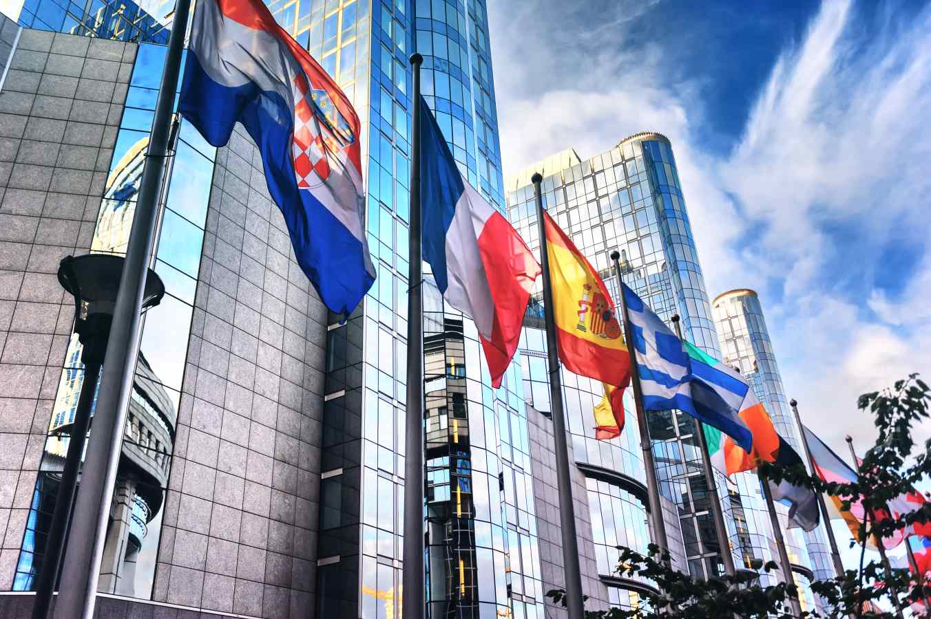 Various flags hung in front of a cityscape.