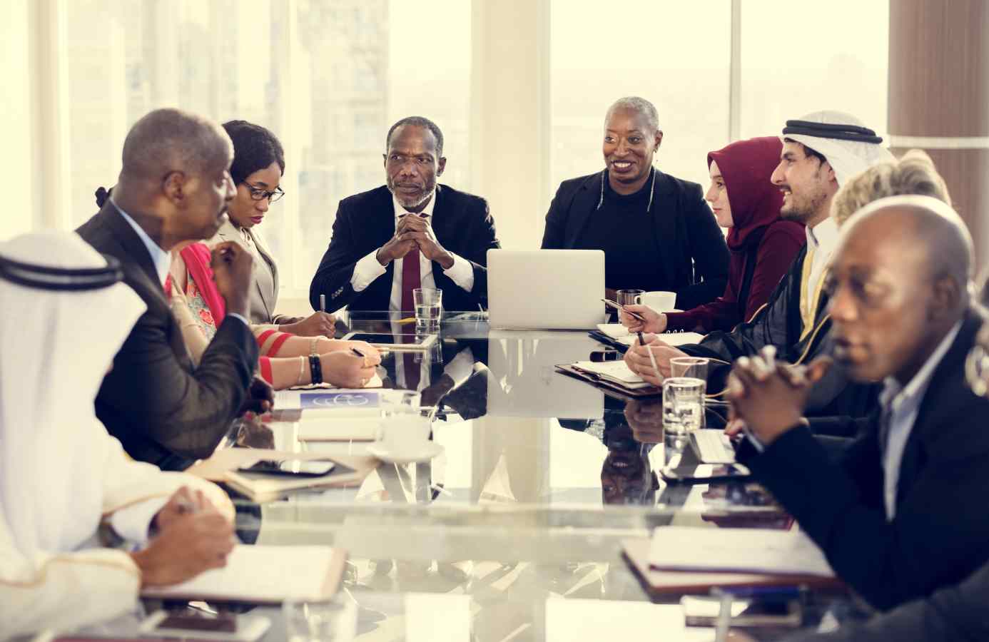 Persons of various cultures doing business around a conference table.